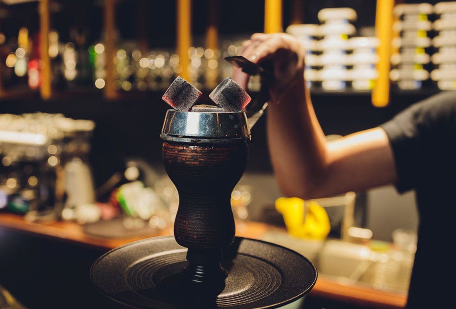 Shisha bowl being prepared with hot coals at a lounge bar